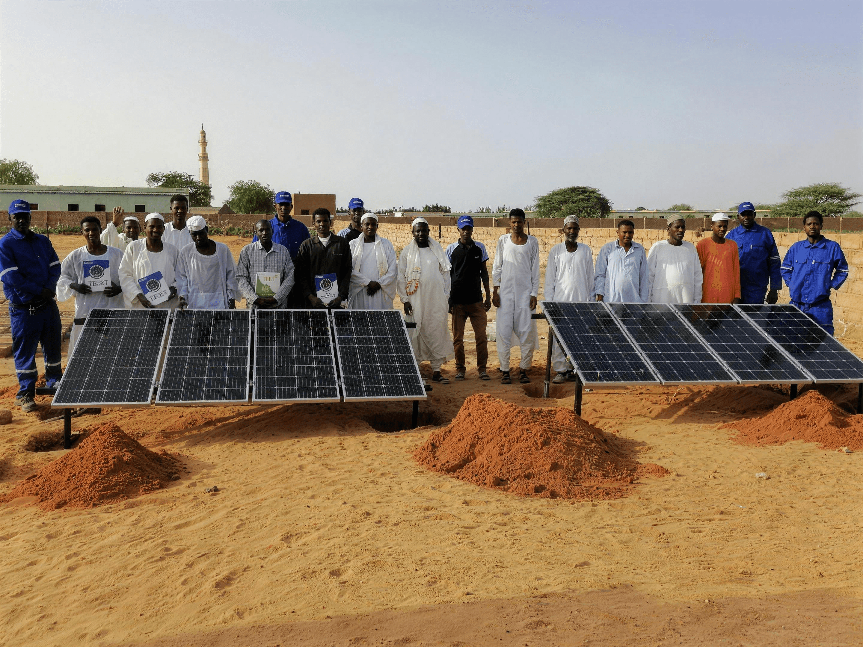 Community members and the Saruest crew beside two newly installed solar arrays